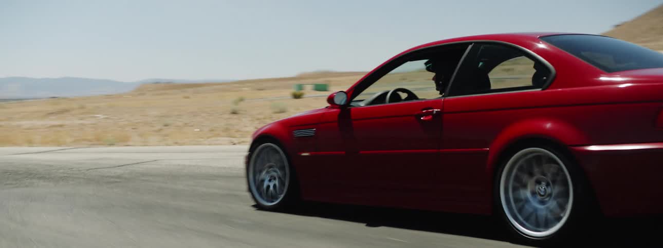 A man is driving a car in a rural area