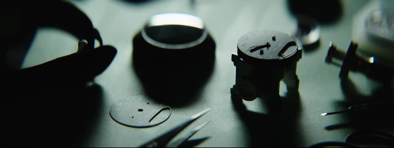 A person hand with a tweezer repairing a watch