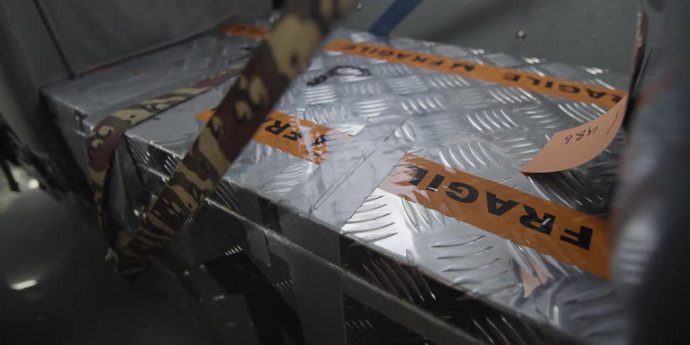 A metal crate marked as fragile