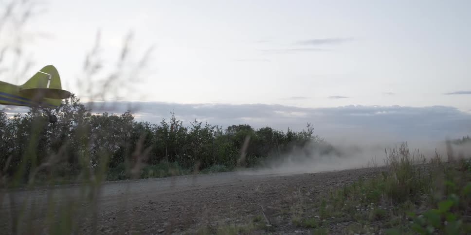 A small plane taking off from a dirt runway