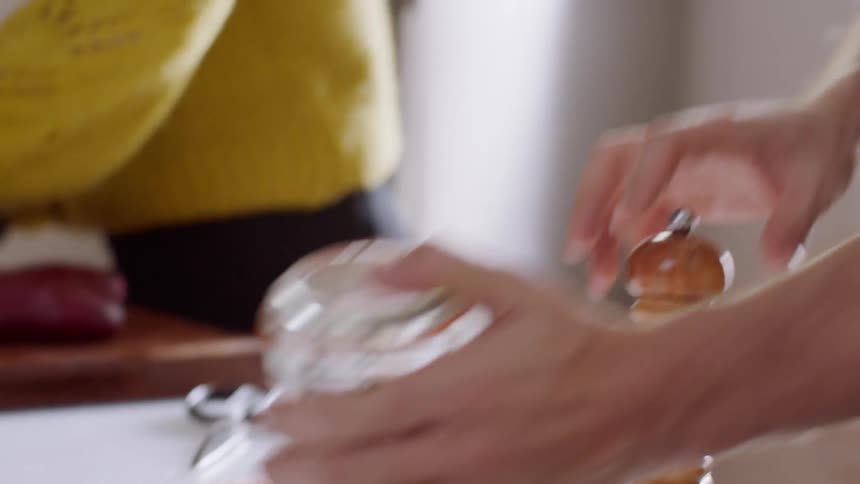 A man and a woman prepare food by seasoning salmon fillets