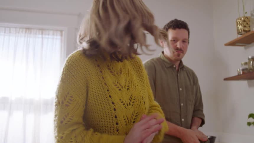 A man and woman prepare food in their kitchen