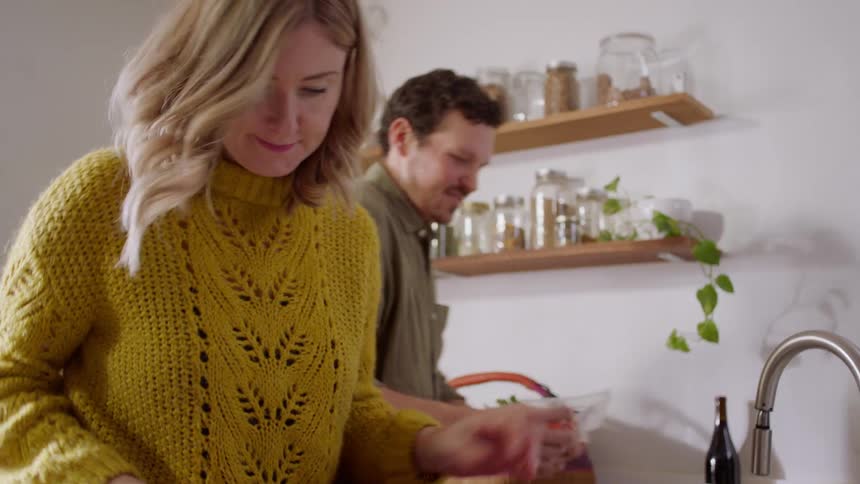 A man and woman cook at home