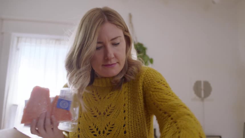 A woman unpacks groceries at home