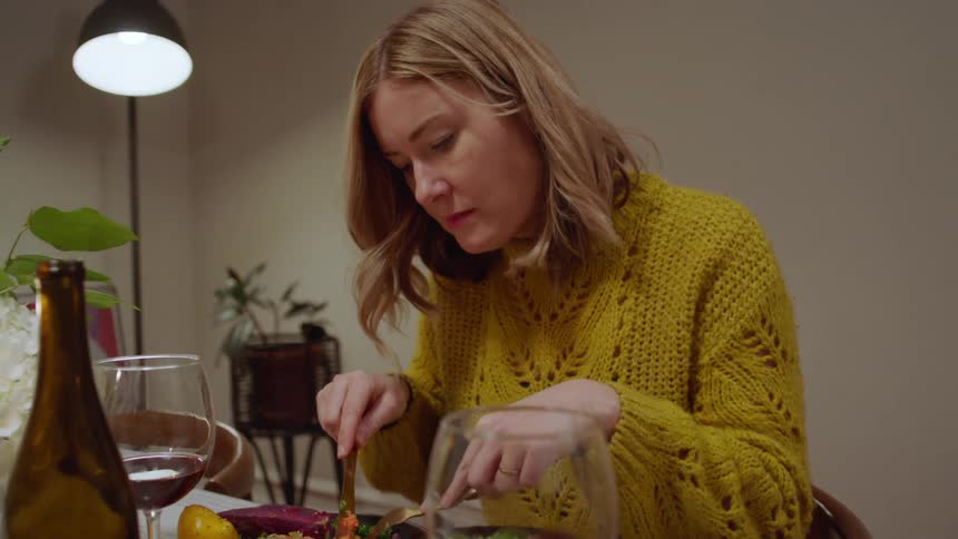 A man and woman sit and eat dinner together