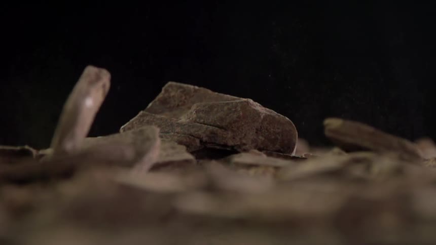Pieces of dark chocolate falling onto each other