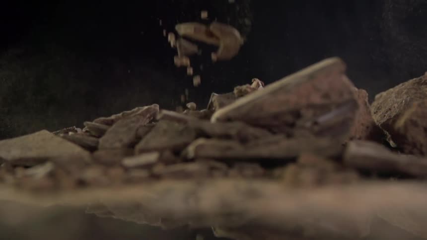 Huge chunks of broken up chocolate falls on a counter