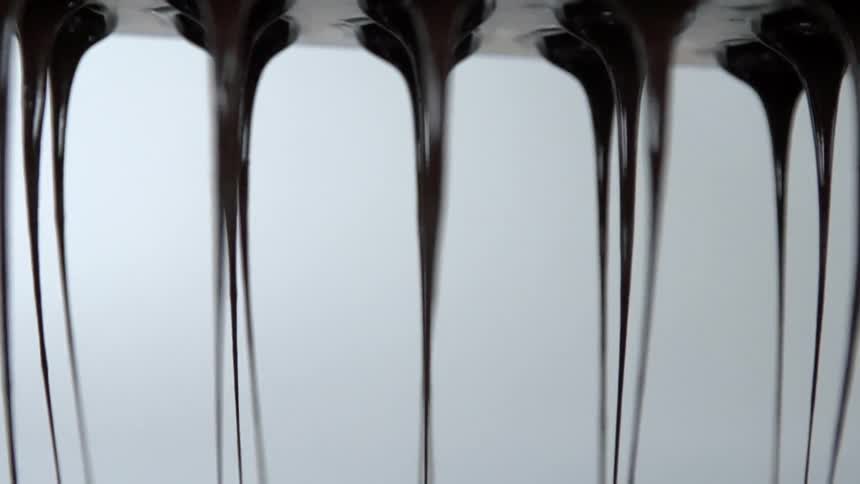 Chocolate dripping from a machine in a factory
