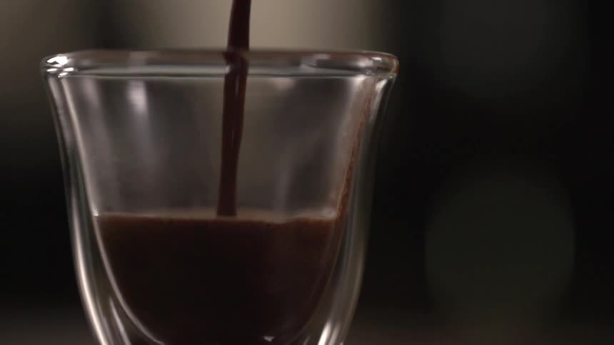 Hot coffee pouring on small glass cup