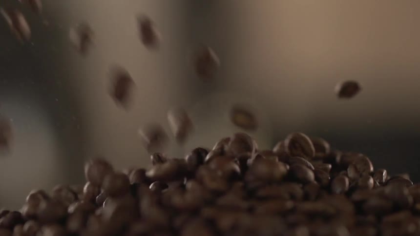 Coffee beans tumble down into a pile