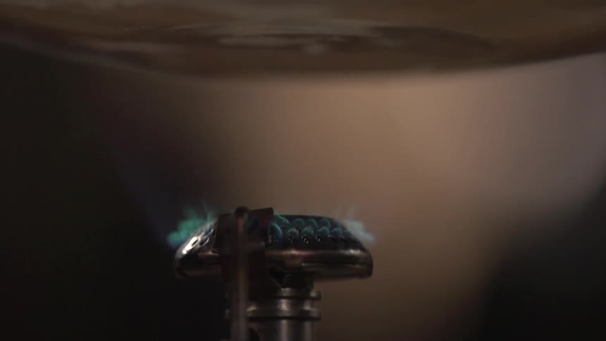 A flame burns under liquid