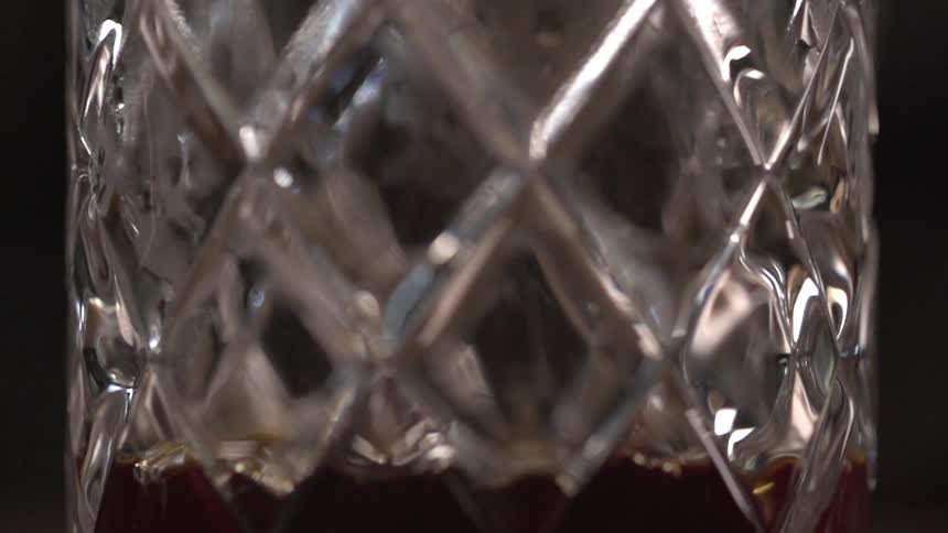 Brandy drips into a diamond patterned drinking glass