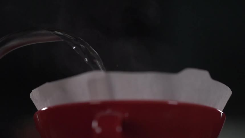 Water pours into a paper filter stuck in a red cup