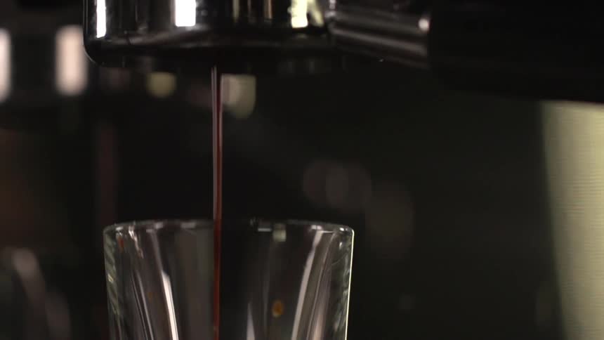 Brewed coffee streams into a glass