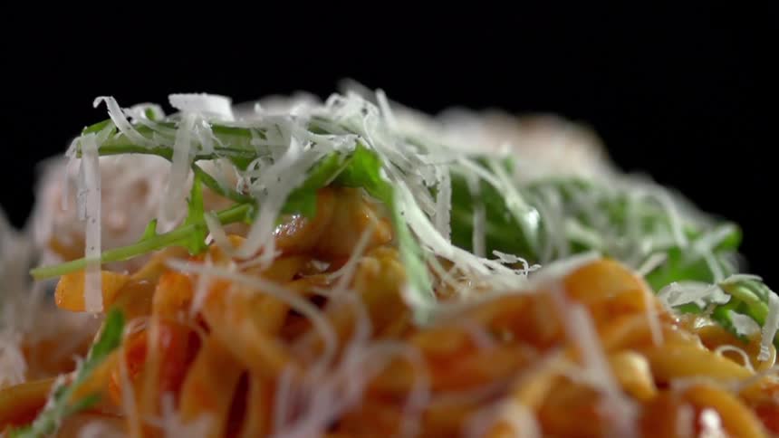 Shredded cheese is sprinkled over a dish