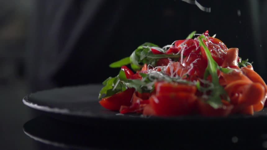 Cheese falling on a plate of food in a studio
