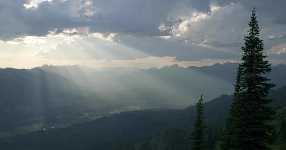 Sun rays shining through the clouds over Rocky Mountain valley
