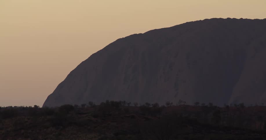 The sun begins to hit Uluru in Australia at dawn
