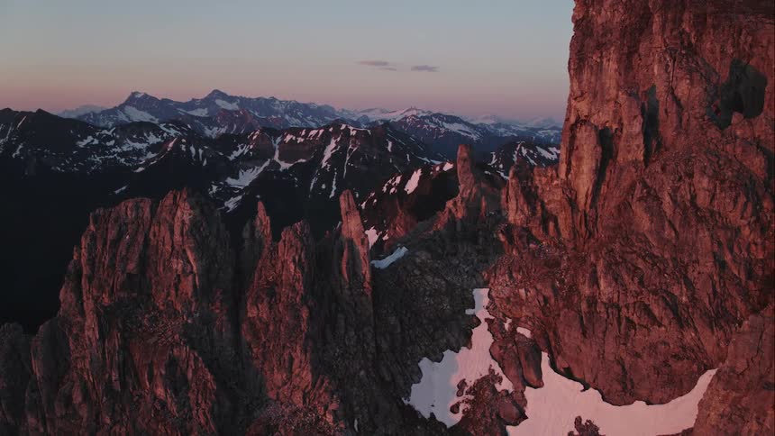 A mountain range with some snow covering it