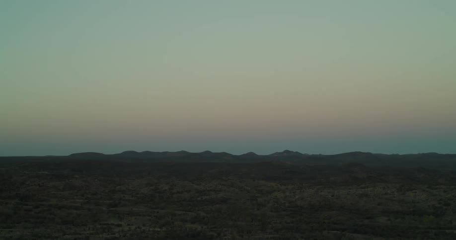 Small hills on the horizon of a desert landscape with brush