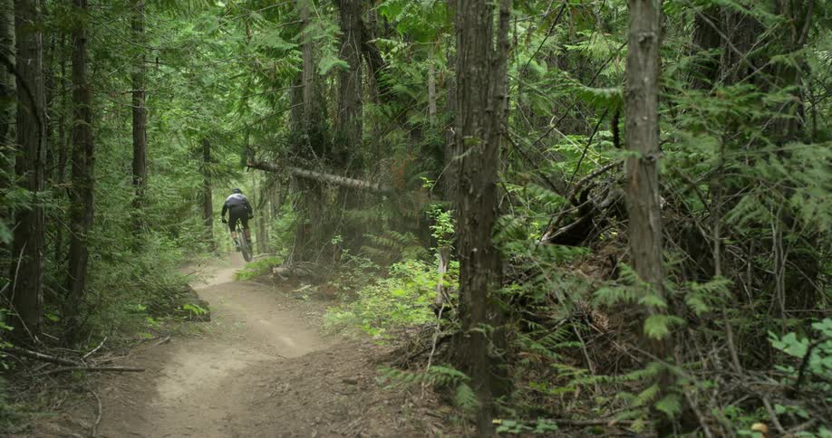 A mountain biker quickly rides high speed corners down trail 2