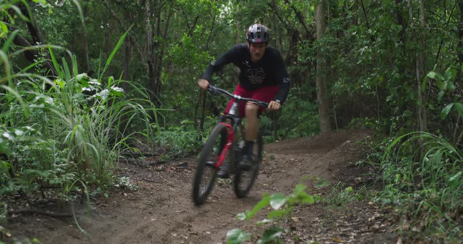 Bicyclists rides through fast corners on mountain bike trail