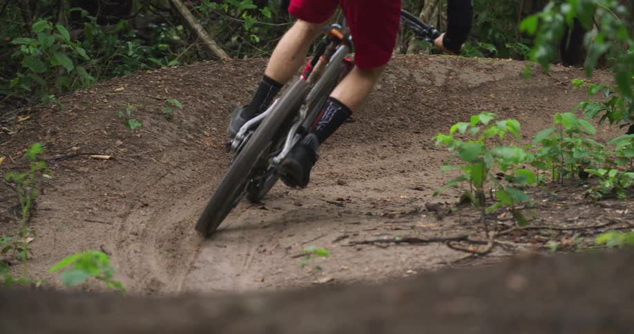A man rides a mountain bike through a dirt corner on a trail