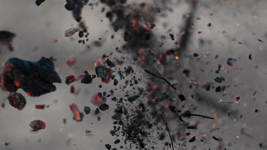 Ashes and burning chunks of wood fly through the air