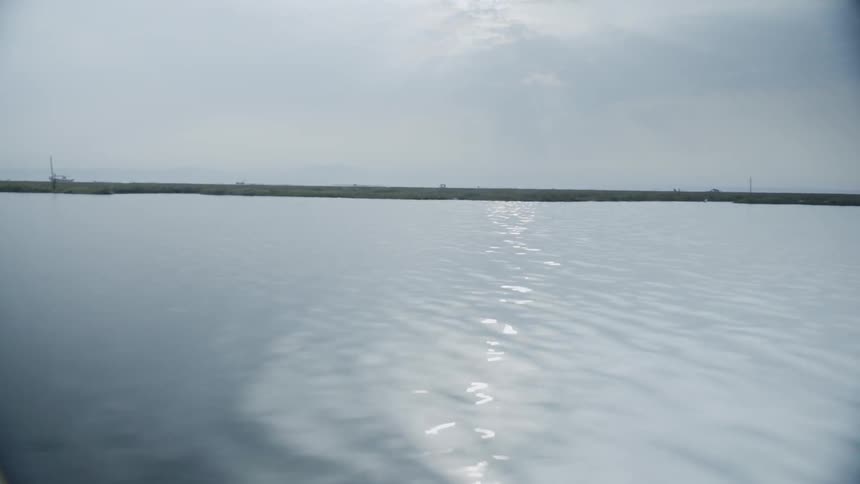 A quiet lake with a vehicle in the distance