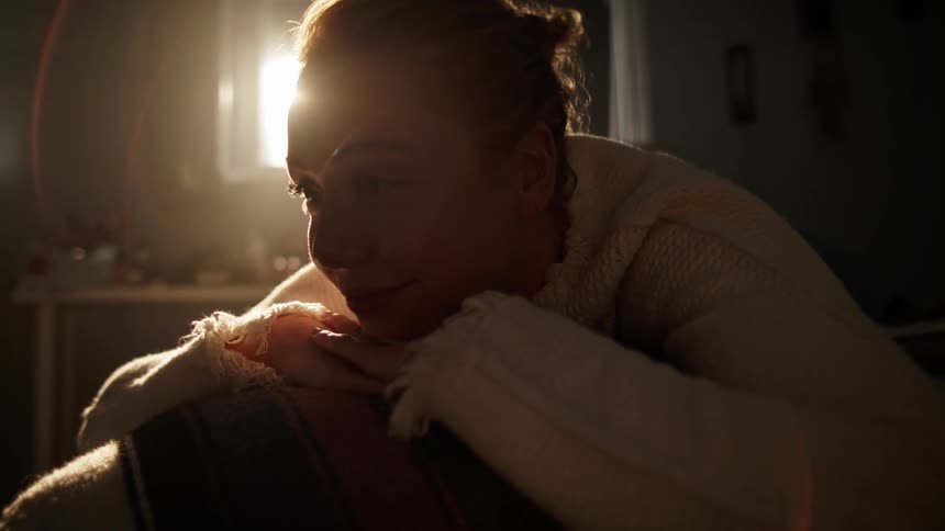 A woman leans on her hands and smiles