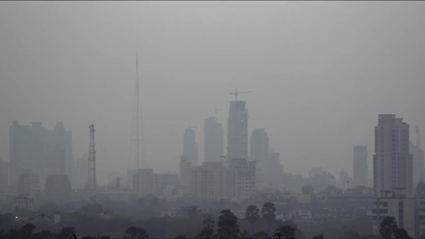 City buildings and skyline with construction cranes on rooftops on a gray foggy day