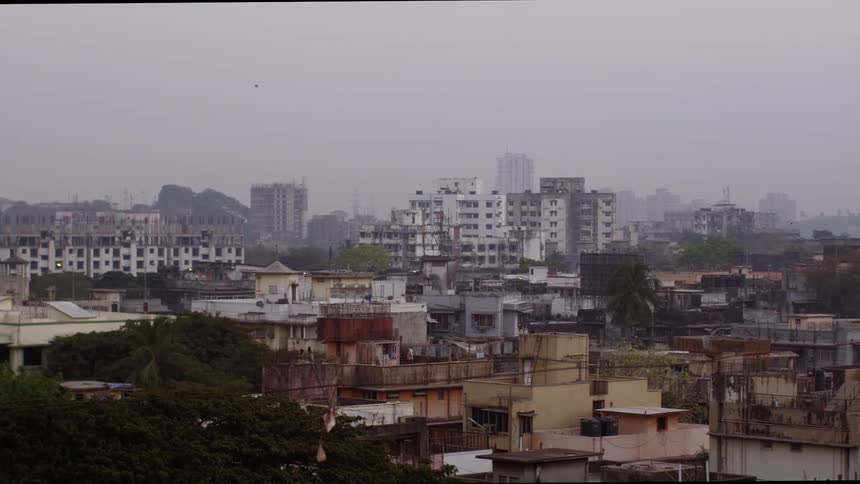 Smog hangs over a third world city and neighboring slum
