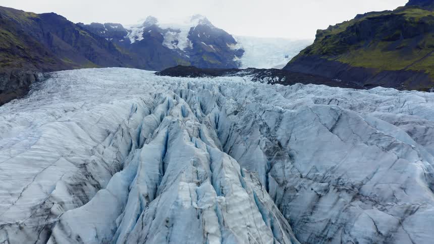 Jagged ridges of massive icebergs with mountains behind