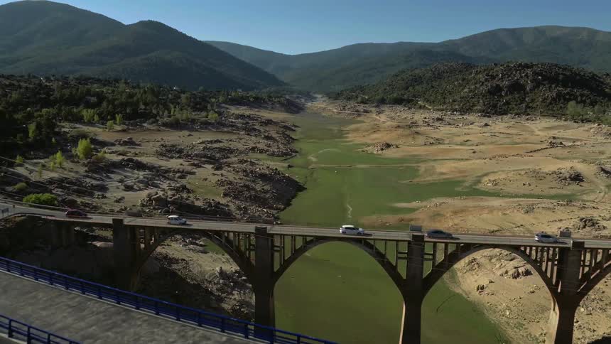Cars drive across a bridge over a river