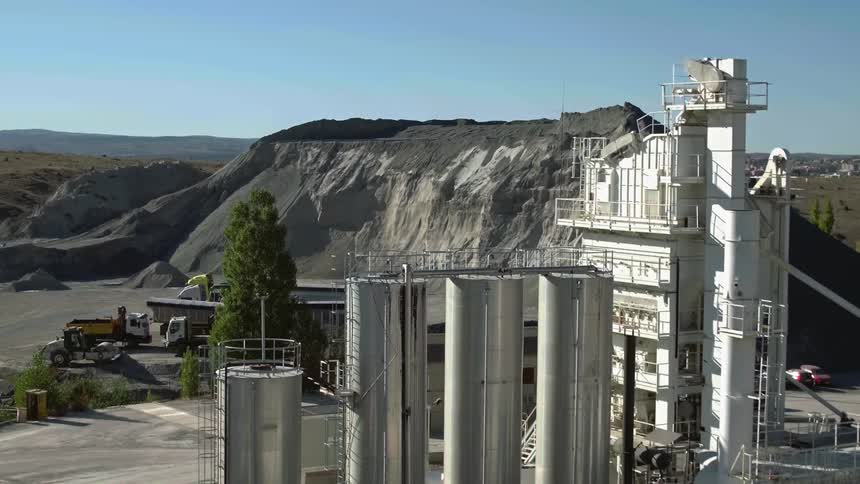 A small refinery near a low mountain on a sunny day