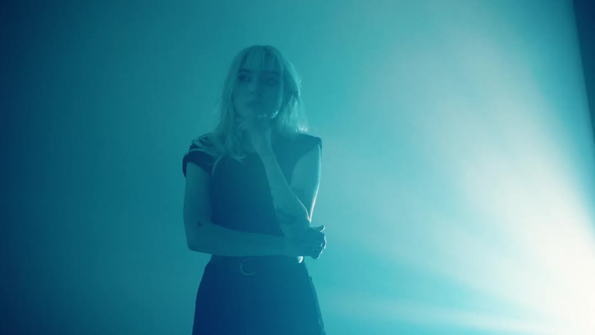 A teenager stands in a bright light inside