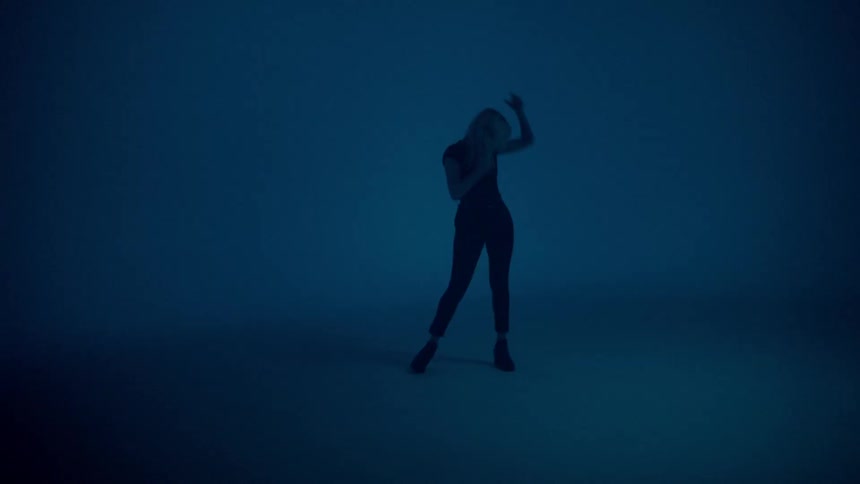 Young woman posing in front of dark blue background with strobe effects