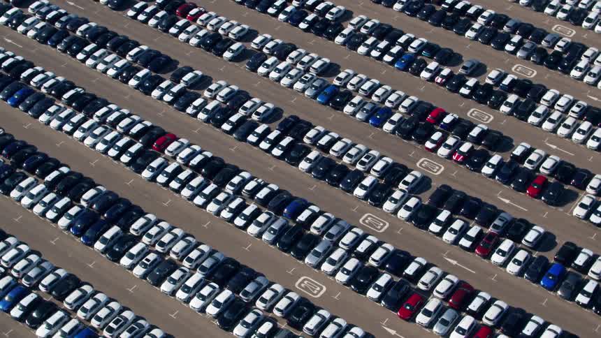 An aerial view of a lot filled with cars is displayed