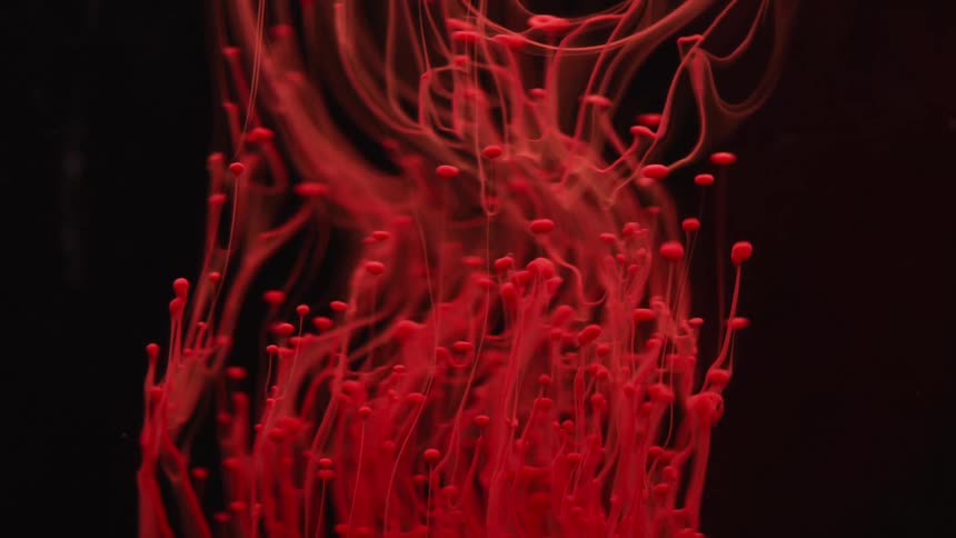 Droplets of red liquid flow upwards