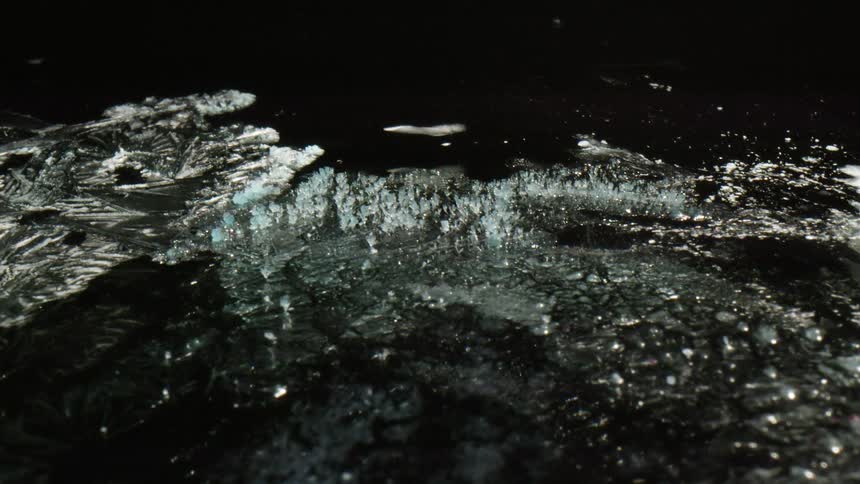 Crystals or ice shimmer and glow against black