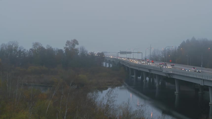 Morning commuters driving through thick fog on a busy highway