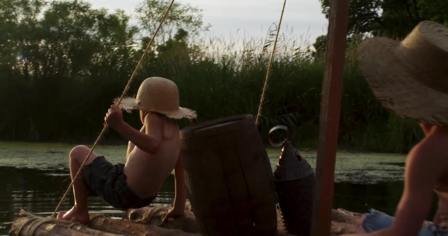 Two boys float on a raft in the water