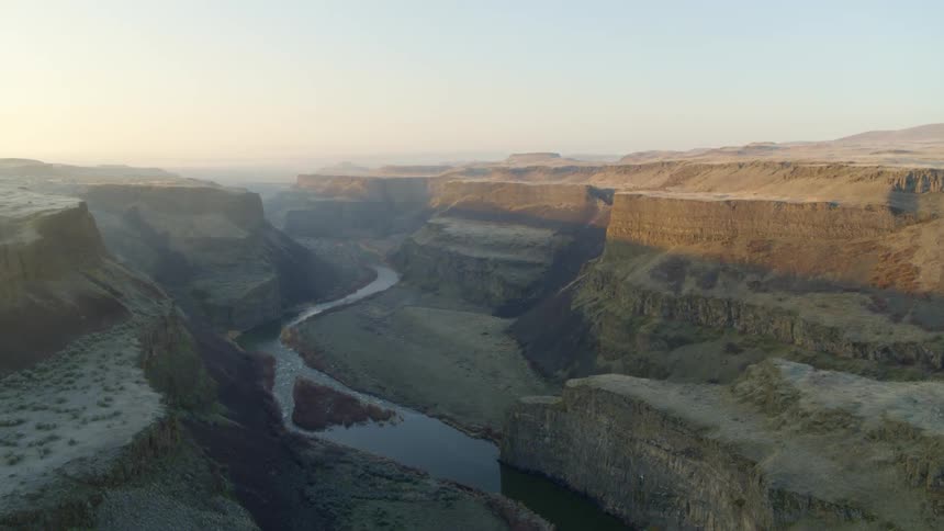 Revealing a curving river that winds along the bottom of a deep and long desert canyon