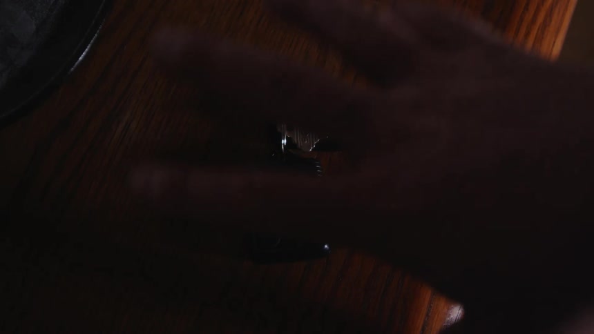 A hand grabs car keys from a wooden table