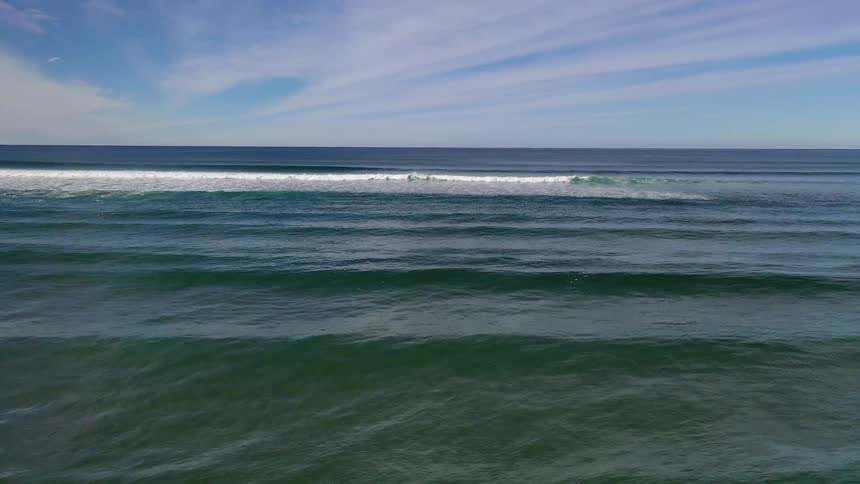 Bluegreen ocean waves rolling in towards the camera