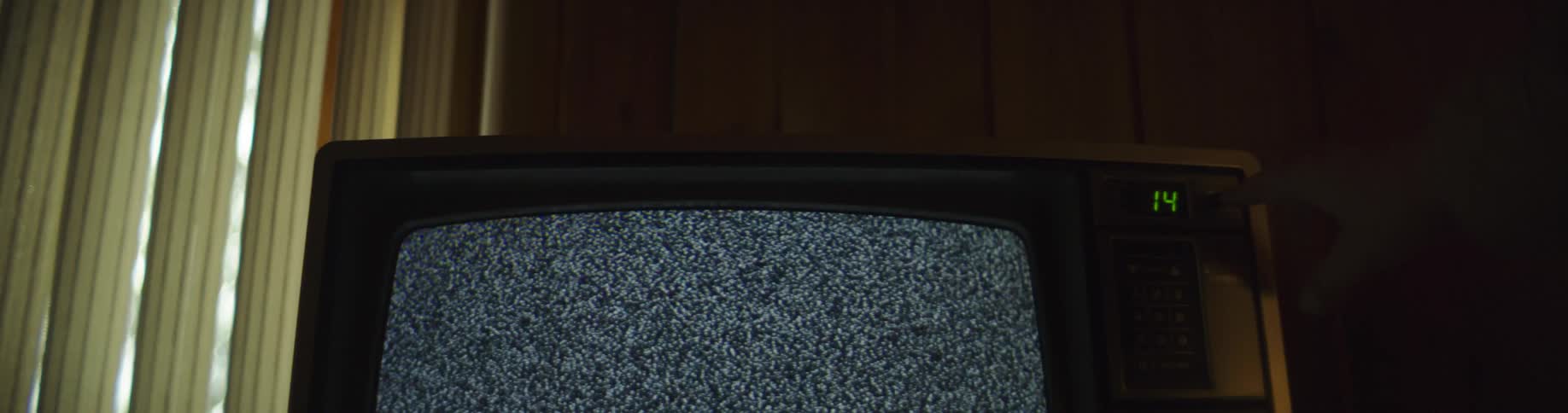 An old television displays static before turning off