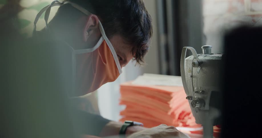 A man in a factory sews