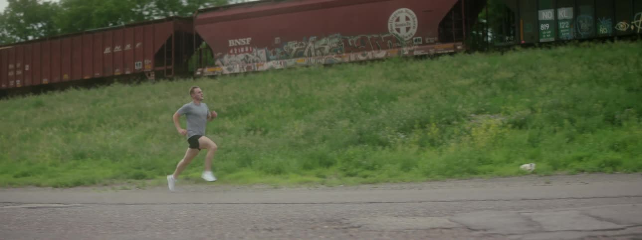Runner races train moving at top of slope