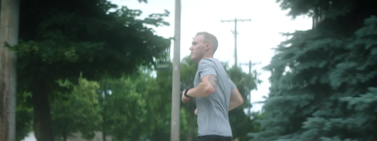 A white man jogs through a suburb