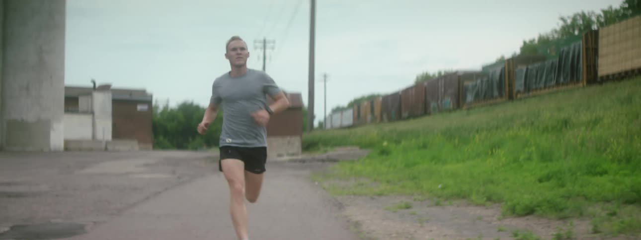 A man running with a cargo train moving to the left of him